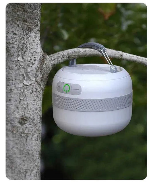 NATFIRE LV10 lantern hanging on a tree branch outdoors.