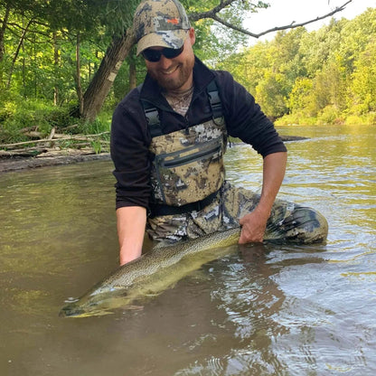 Fishing enthusiast wearing Bassdash Veil Camo Chest Waders in a river.