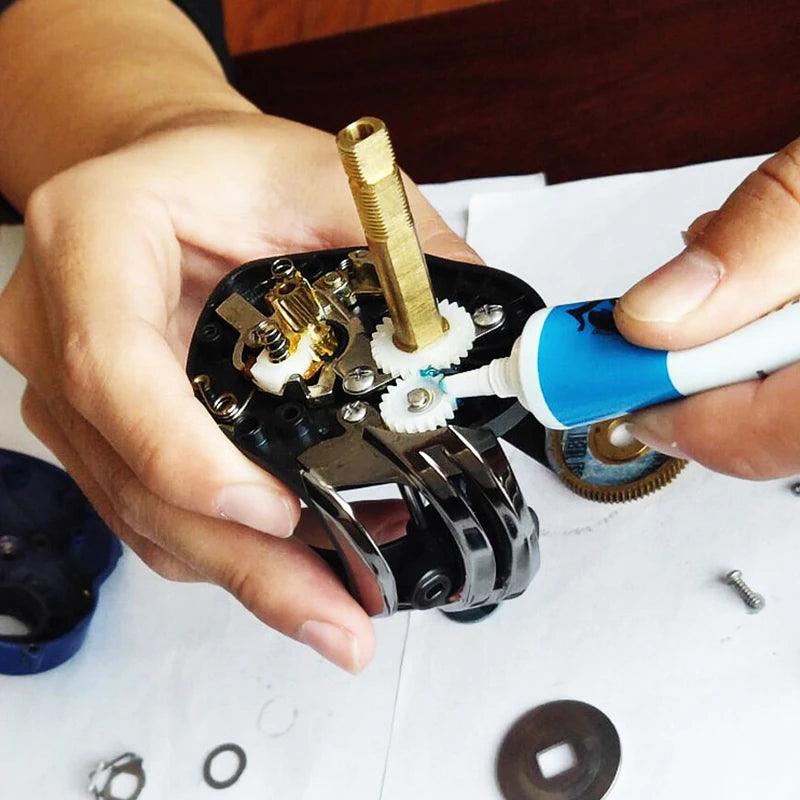 Applying grease to fishing reel gears with Premium Reel Care Kit for smoother casts and maintenance.