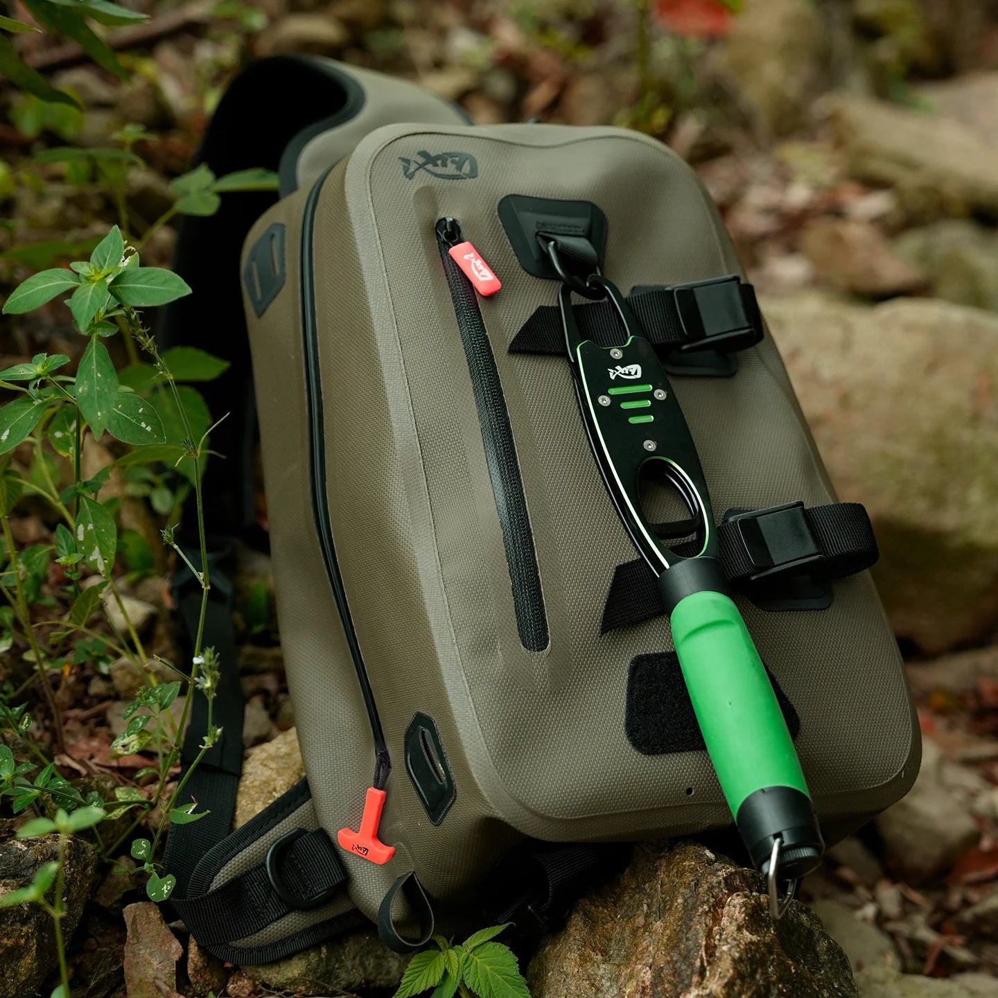 Green and black outdoor tool case with tools on a natural background