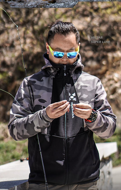Man in camouflage jacket and reflective sunglasses holding a fishing rod, with 'Huk' branding visible.