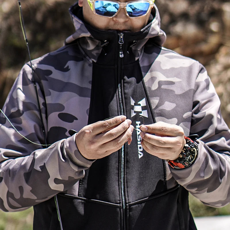 Person wearing a camouflage jacket with a brand logo, holding fishing equipment.